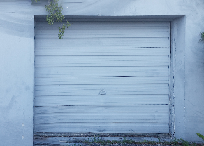 Old faded flat-panel garage door before replacement